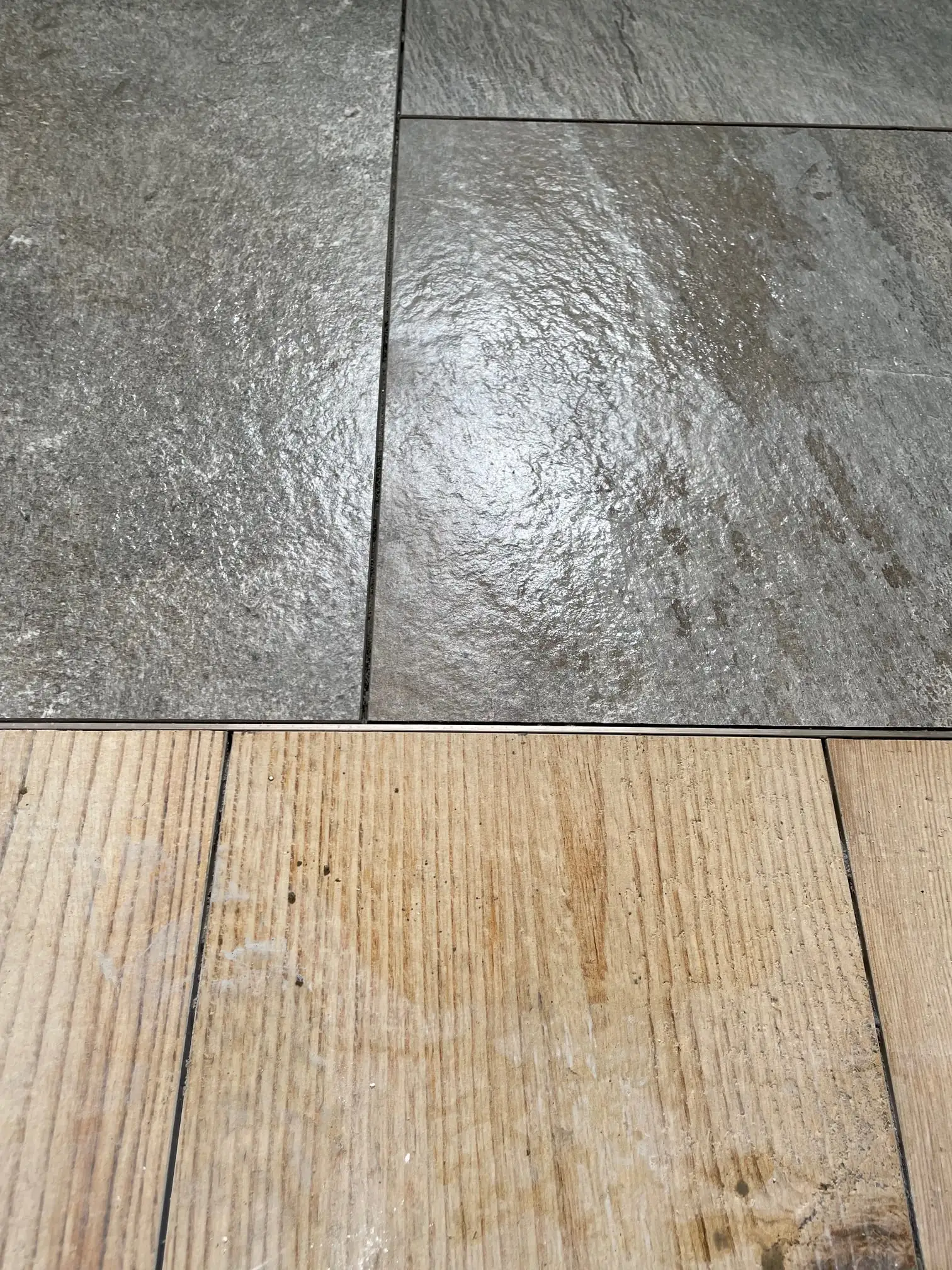 Jonction entre un carrelage effet pierre grand format et un parquet