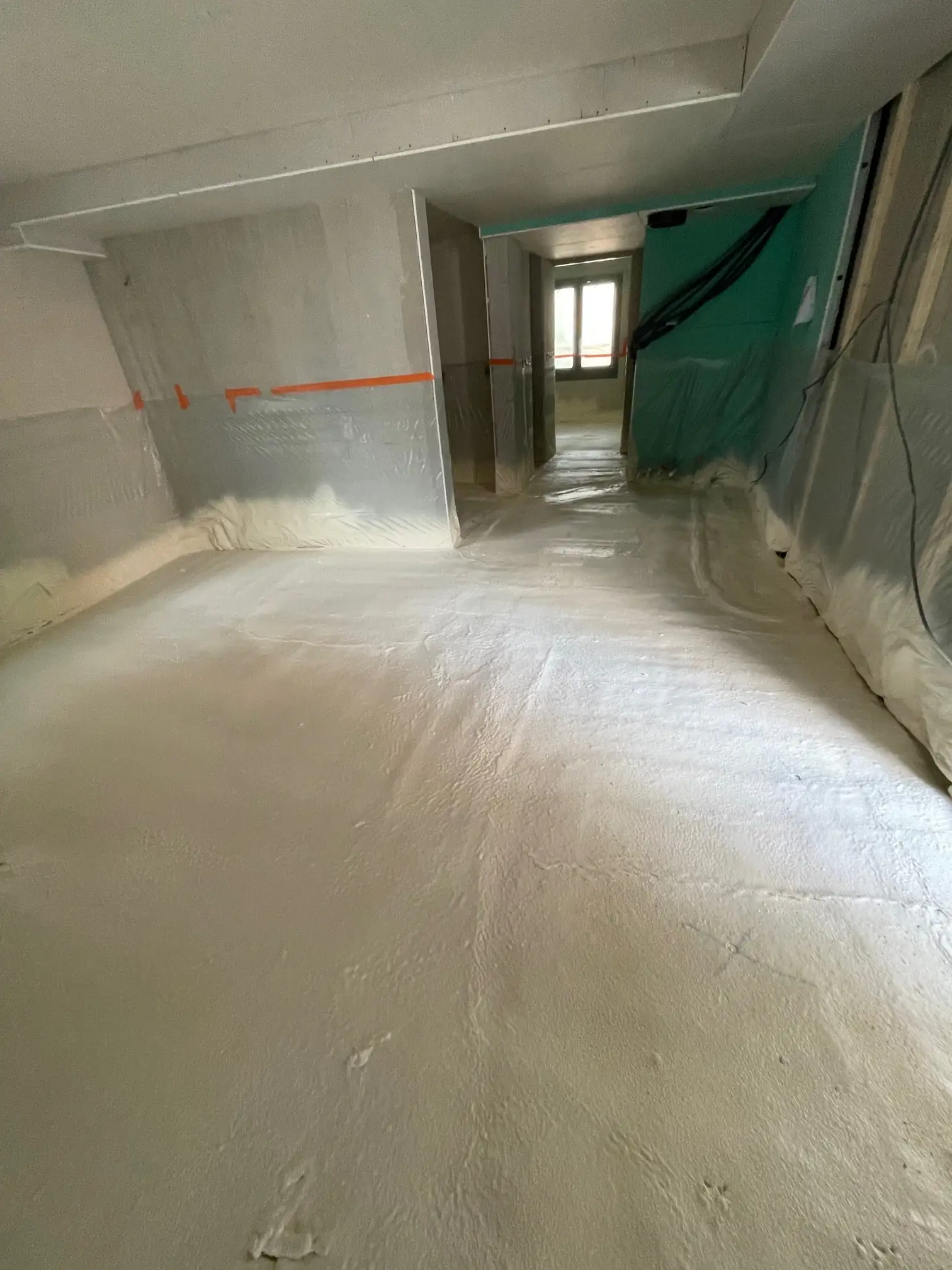 Chape fraîchement coulée dans un couloir en rénovation