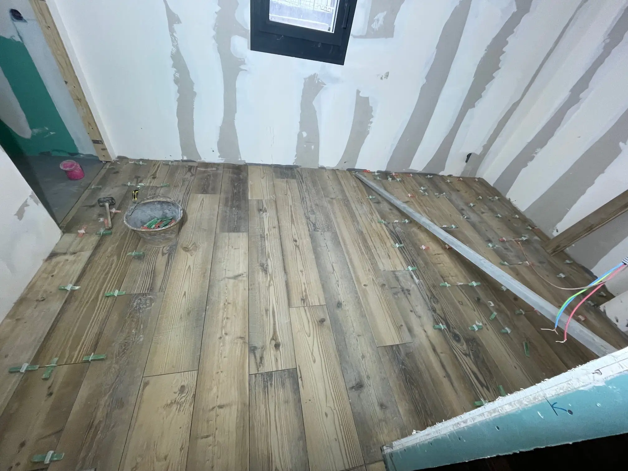 Pose d’un parquet en bois vieilli dans une pièce en plaques de plâtre